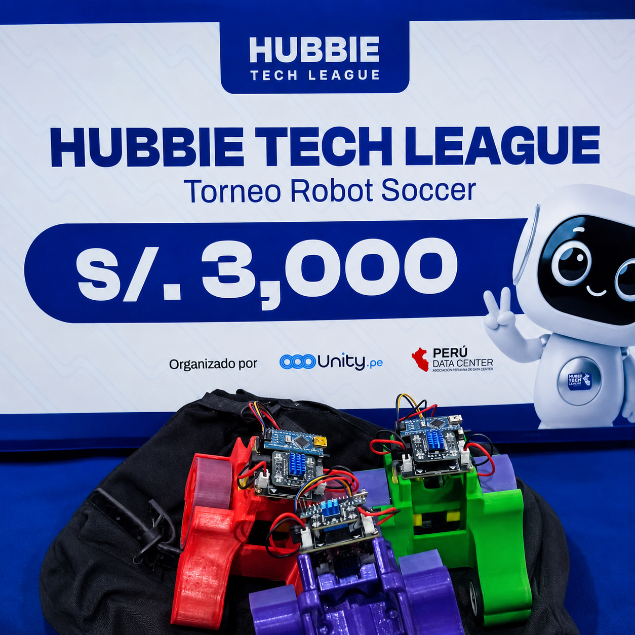 Robot de competencia de Yati-Bots junto a un trofeo y un control móvil